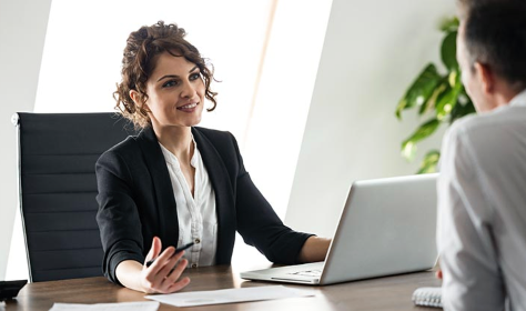 HR manager reviewing employee profiles and payroll information on a laptop